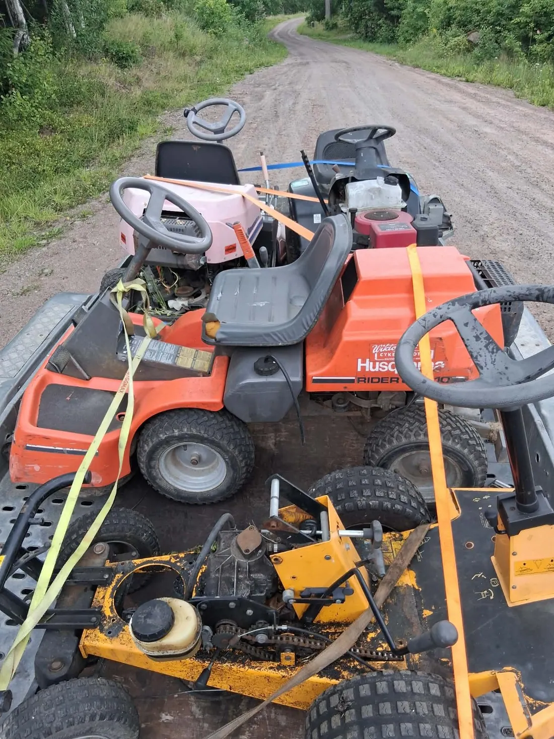 Flera åkgräsklippare samlade på en släpvagn
