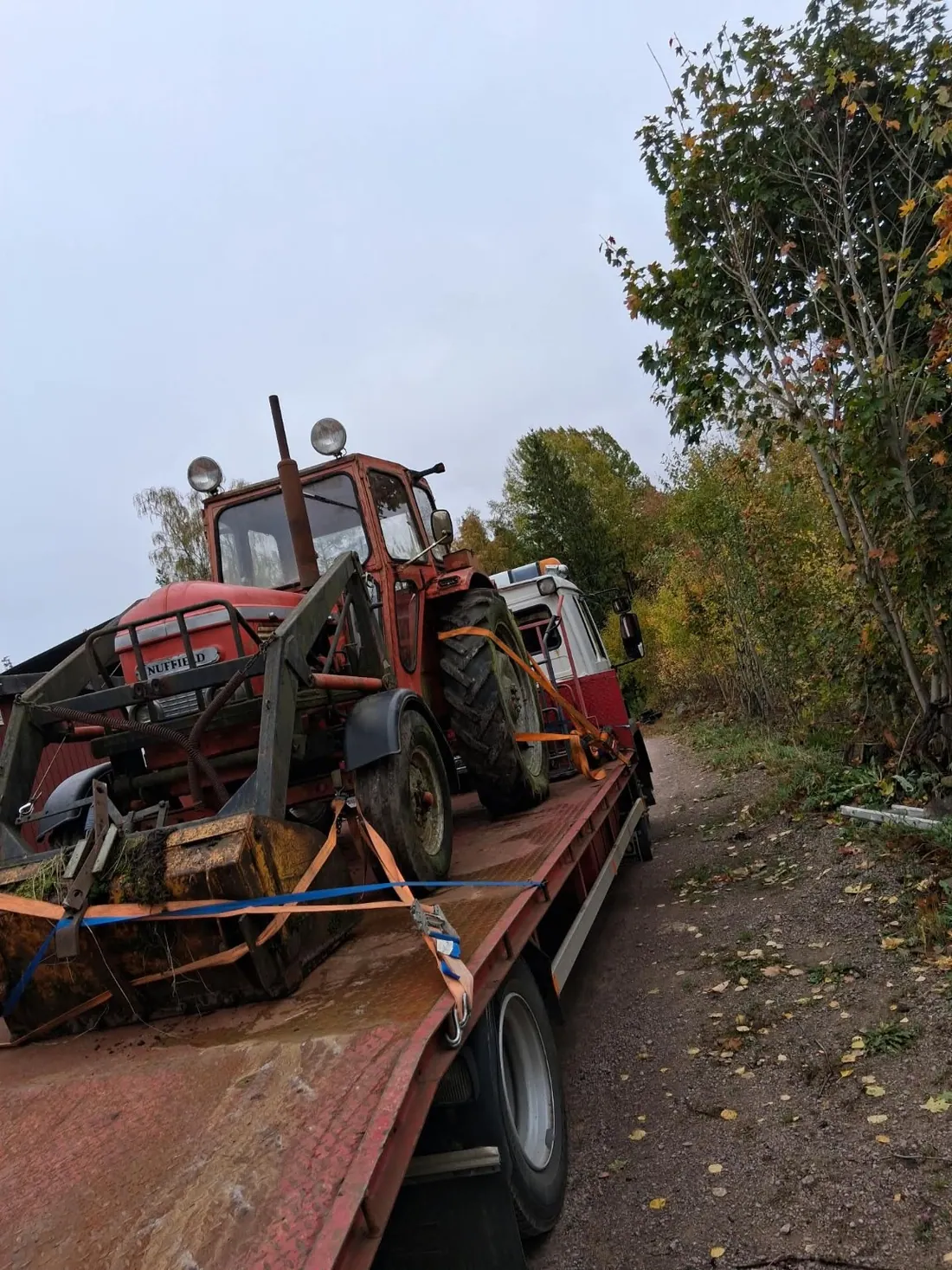 Traktor lastad på flak vid en maskinhämtning