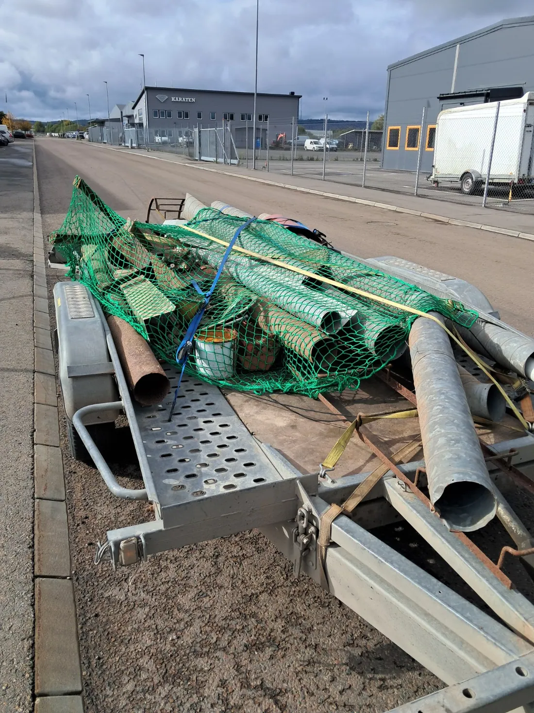 Metallrör och andra metalldelar lastade på släpvagn